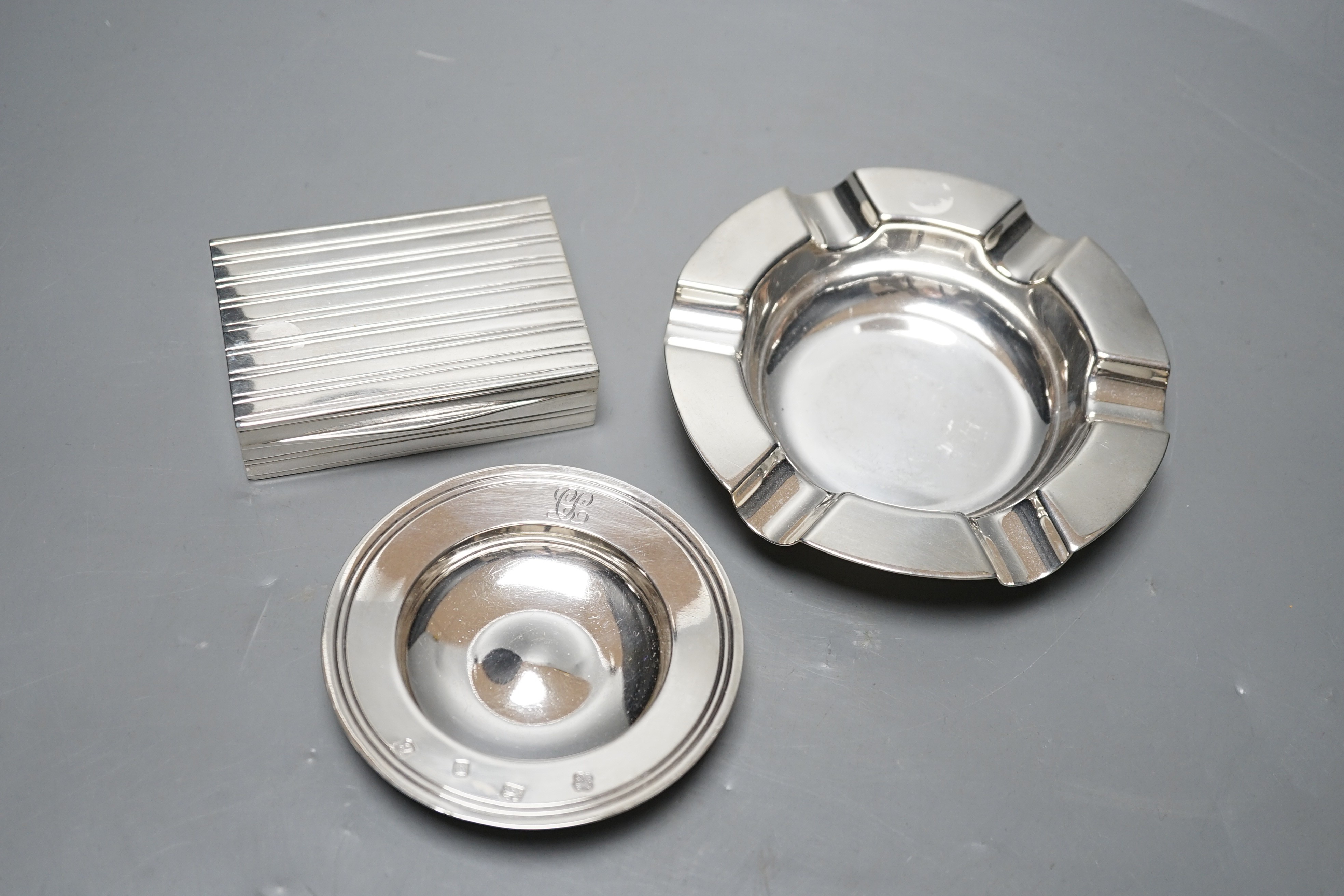 A George V silver ashtray, Mappin & Webb, Sheffield, 1928, 13cm, a modern Asprey & Co small dish and a continental white metal box and cover, gross 12.2oz.